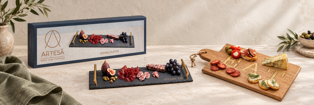 Slate serving tray with brass-coloured handles beside a wooden serving board