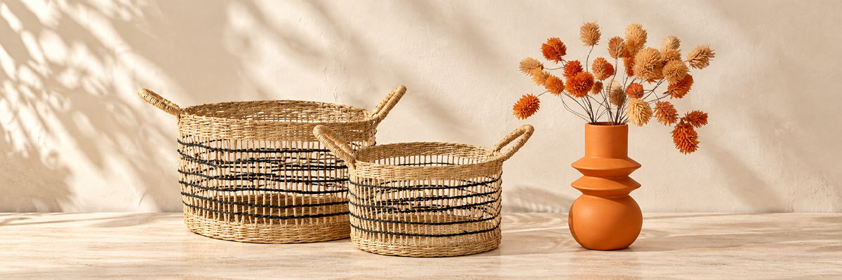 Seagrass Open Weave Baskets and Terracotta Totem Vase arranged in a warm, softly lit setting.