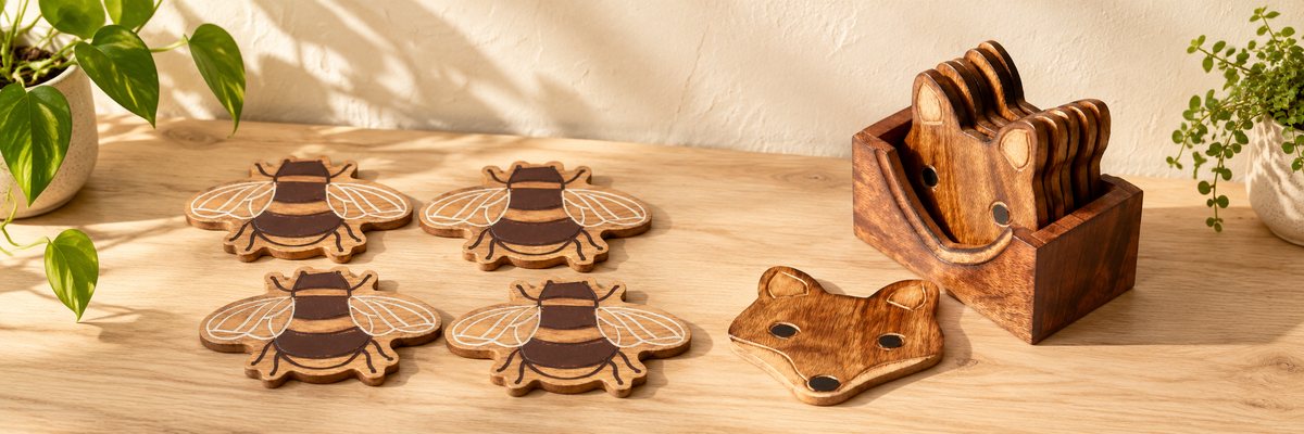 Mango Wood Bee Coasters - Set of 4 and Wooden Fox Coasters - Set of 6 arranged in a warm, softly lit setting.