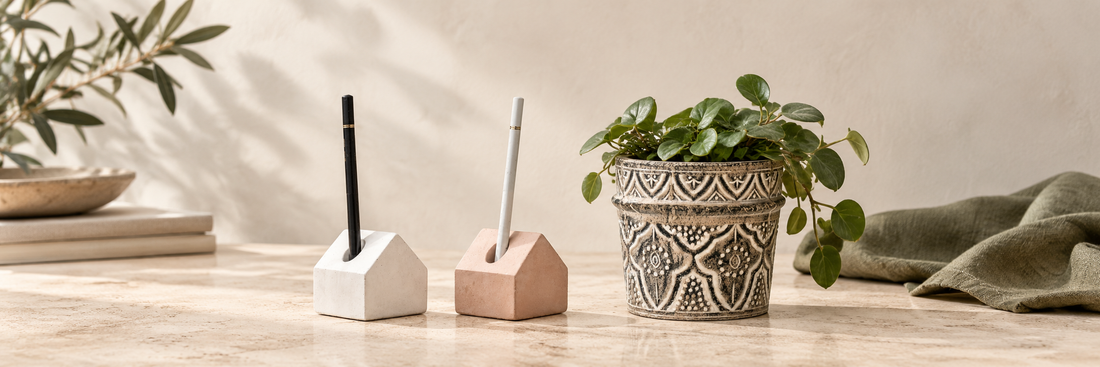 House-shaped concrete pen holders beside a patterned plant pot