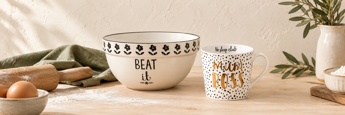 Cream mixing bowl and patterned mug on a kitchen table