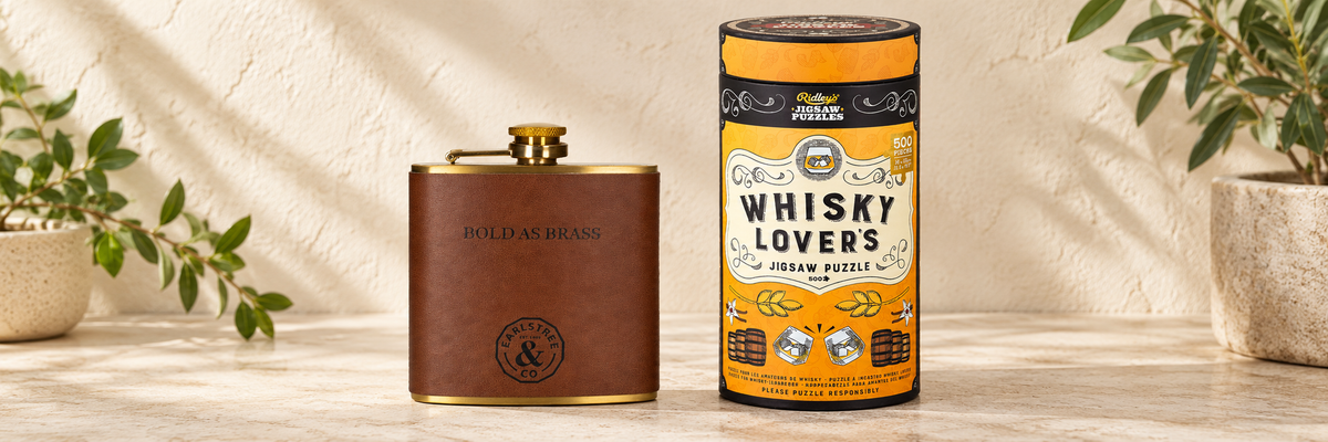 Earlstree &amp; Co Stainless Steel Hip Flask and Whisky Lovers Jigsaw Puzzle - 500 Pieces arranged in a warm, softly lit setting.