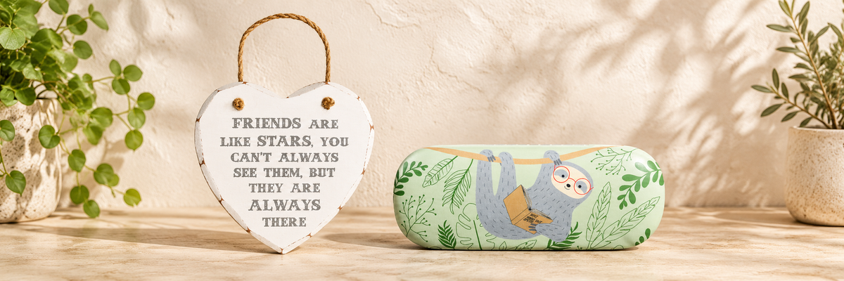 Friends Are Like Stars Heart Plaque and Sloth Glass Case arranged in a warm, softly lit setting.
