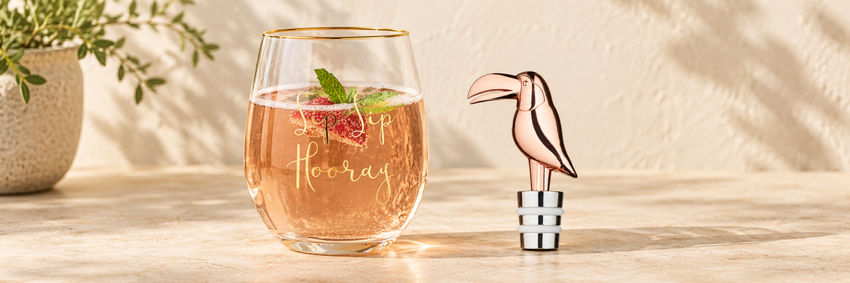Toucan Bottle Stopper and Ava & I Sip Sip Hooray Wine Glass - 590ml arranged in a warm, softly lit setting.