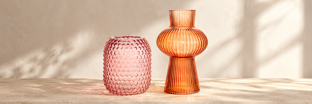 Glass Bobble Vase - Pink and Large Amber Shapely Fluted Glass Vase arranged in a warm, softly lit setting.