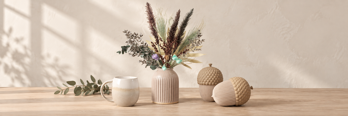 Speckled grooved vase, grey dip-glazed mug and acorn storage containers on a wooden table