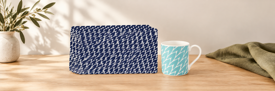 Dark blue leaf-patterned placemats beside a mint leaf-patterned mug