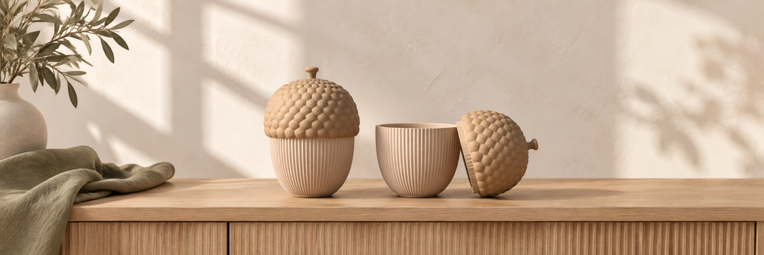 Acorn-shaped storage containers on a pale oak console, with one lid open