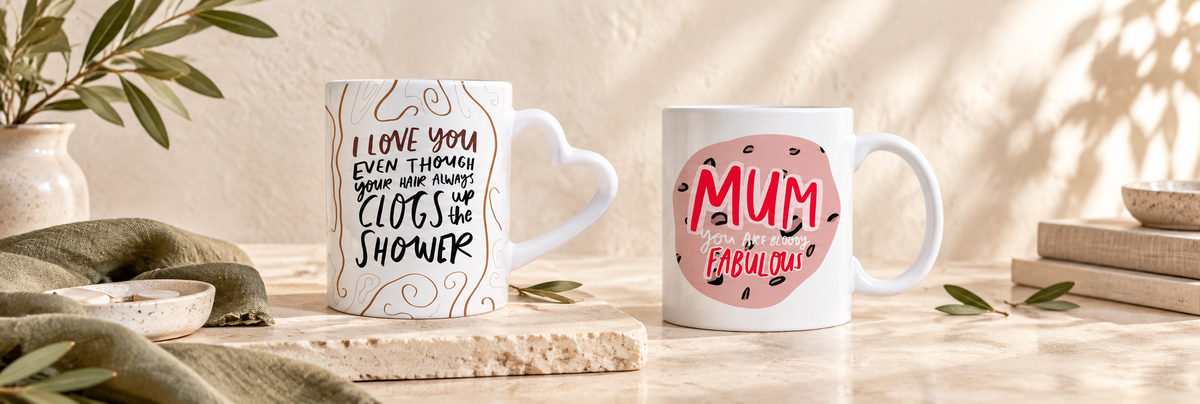 Two white ceramic mugs with colourful printed messages