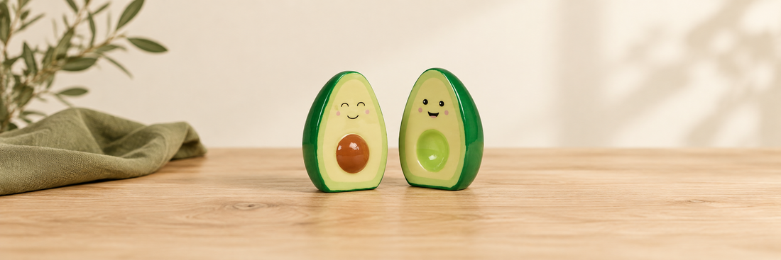Avocado salt and pepper shakers on a pale wooden table