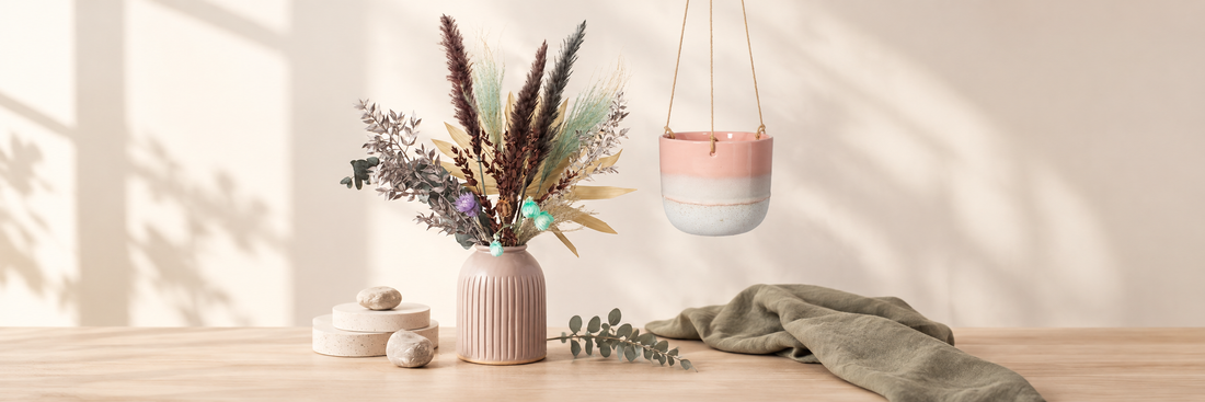 Grooved vase with dried flowers beside a pink hanging planter