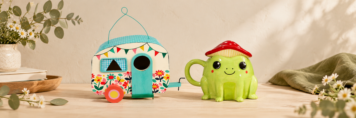 Caravan birdhouse beside a frog mug with a mushroom lid