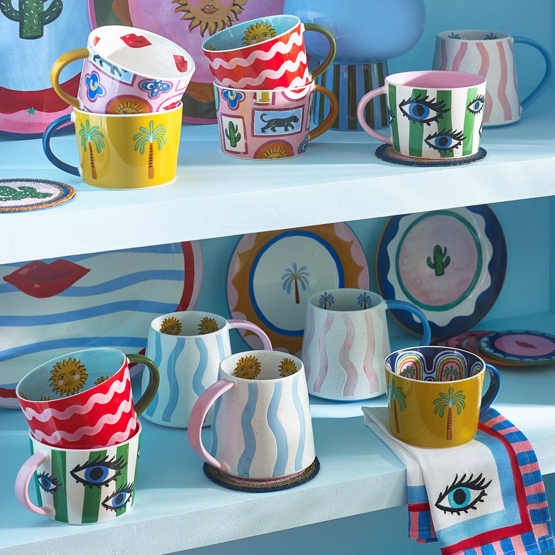 Eleanor Bowmer Blue Wave Mug displayed with other colourful mugs on kitchen shelves