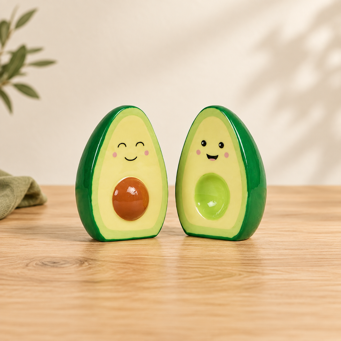 Smiling green avocado salt and pepper shakers on an oak table with olive linen